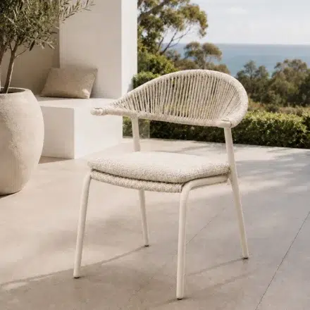 Mila Outdoor Dining Chair with powder coated aluminium frame, beige woven HDPE wicker and outdoor bouclé cushion, available in White and Ivory.